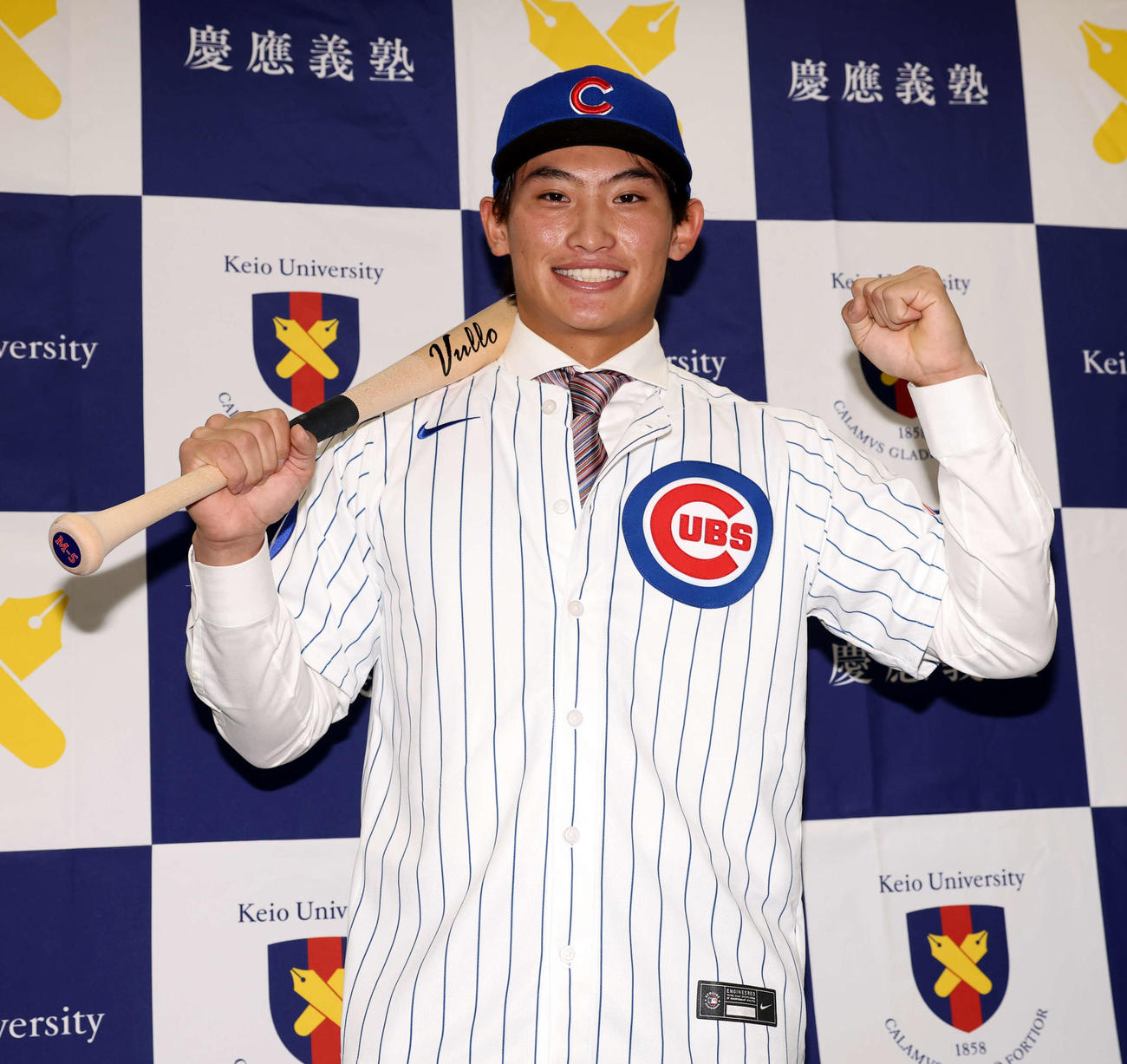 MLBのカブスとマイナー契約契約を結んだ慶大・常松はユニホームを着用し笑顔でポーズ（撮影・浅見桂子）