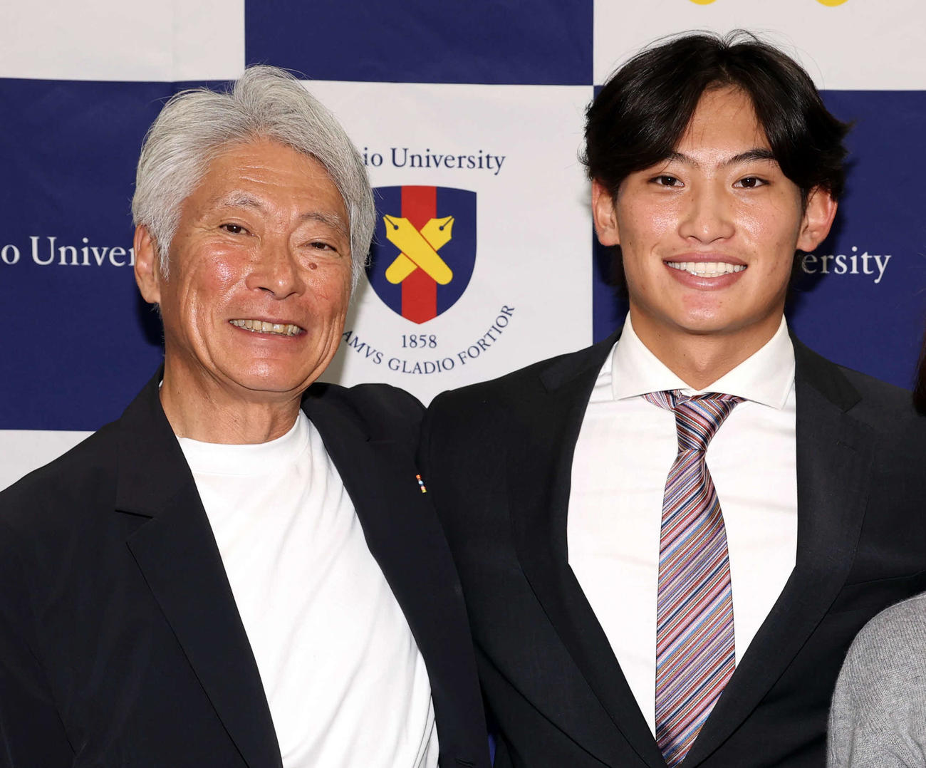 MLBのカブスとマイナー契約契約を結んだ慶大・常松（右）は、会見後、父・広一さんと記念撮影（撮影・浅見桂子）