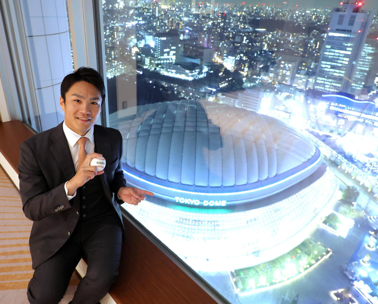 巨人入団会見後、東京ドームが望める部屋で写真に納まる則本