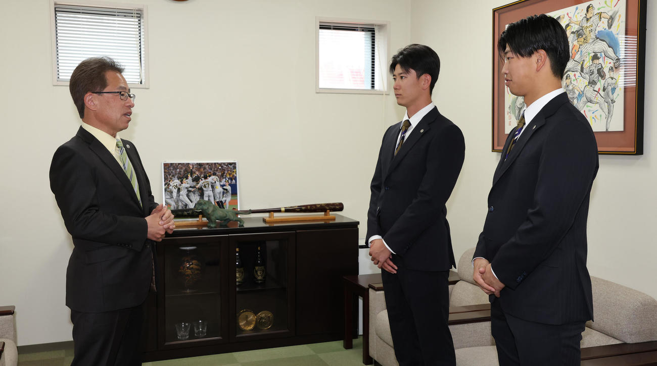 阪神の20歳記念品贈呈式で粟井社長（左）の話を聞く山田（中央）と百崎