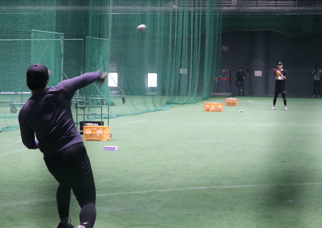 沖縄での自主トレを公開し、ともにキャッチボールする巨人坂本（右奥）と石塚（左）（撮影・小早川宗一郎）