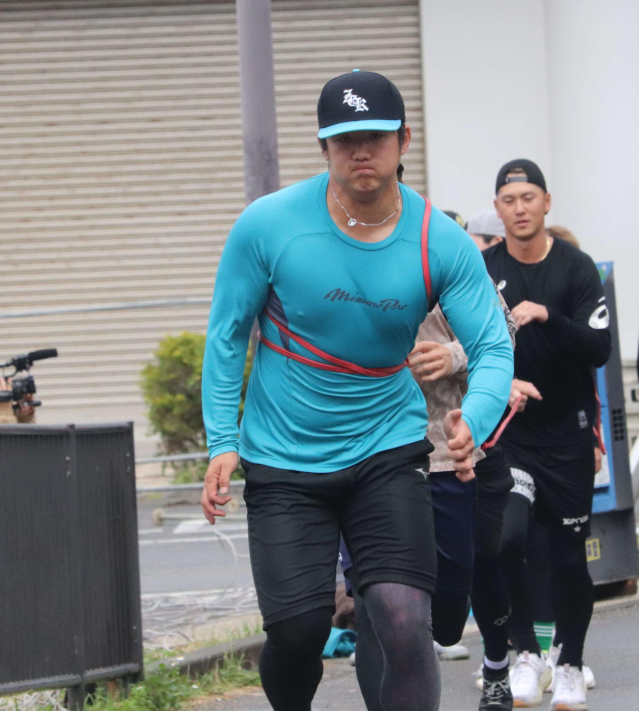 沖縄での自主トレを公開し、チューブを身体に巻いて坂道ダッシュする巨人石塚（撮影・小早川宗一郎）