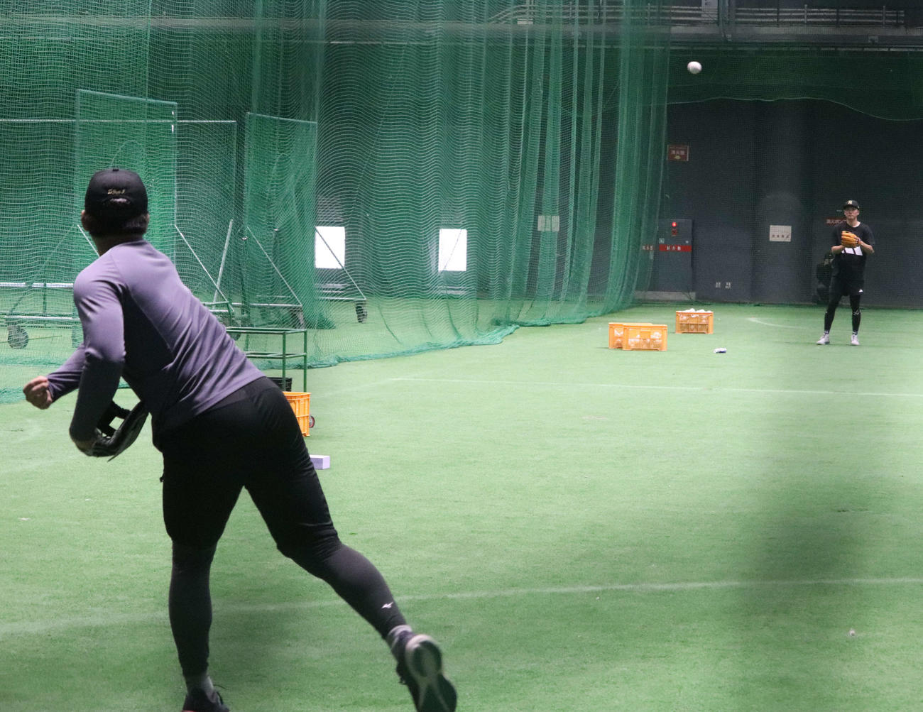 沖縄での自主トレを公開し、ともにキャッチボールする巨人坂本（右奥）と石塚（左）（撮影・小早川宗一郎）