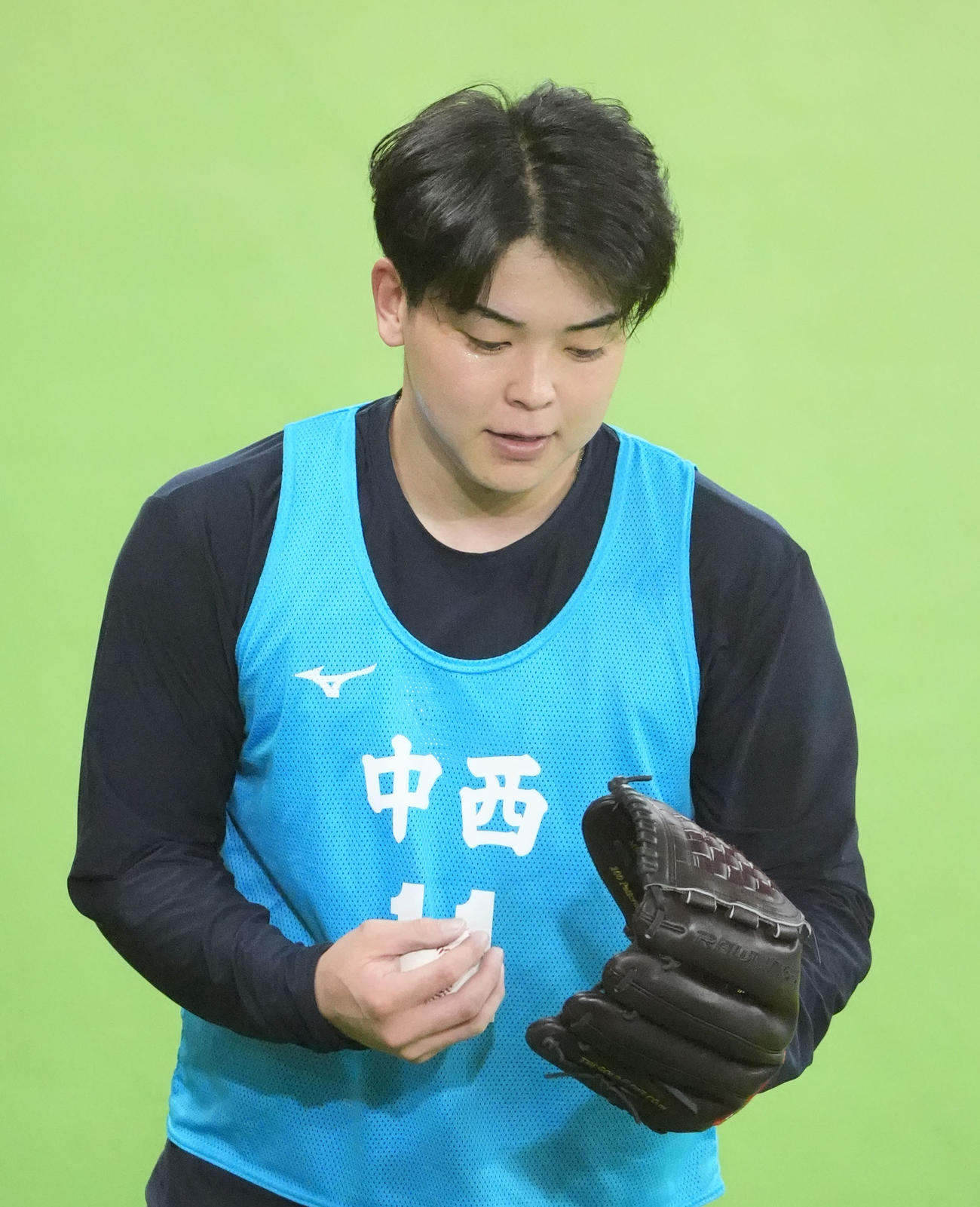投球練習後、グラブを見つめる中日中西（撮影・森本幸一）