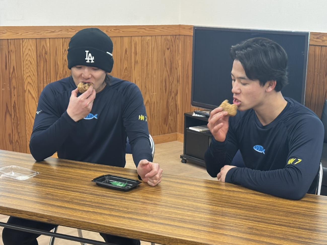 うなぎの入船の「うなぎのおにぎり」を食べるヤクルト長岡（左）と内山（撮影・塚本光）