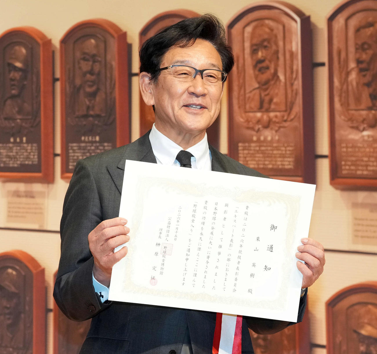 通知書を手に笑顔を見せる栗山英樹氏（2025年1月撮影）