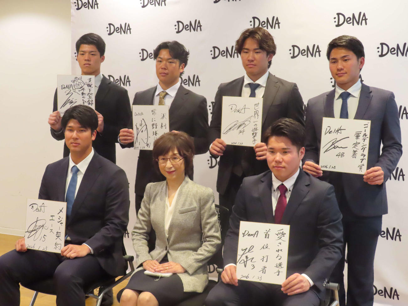 DeNA本社オフィスを訪問し、選手としての目標を記した色紙を手に南場オーナー（前列中央）と記念撮影する新人の、前列左から島田、1人おいて小田、後列左から清水詩、片山、宮下、成瀬（撮影・山本佳央）