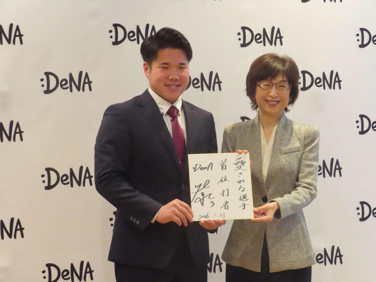 「選手としての目標」を記した色紙を手に記念撮影に応じるDeNA小田（左）と南場オーナー（撮影・山本佳央）
