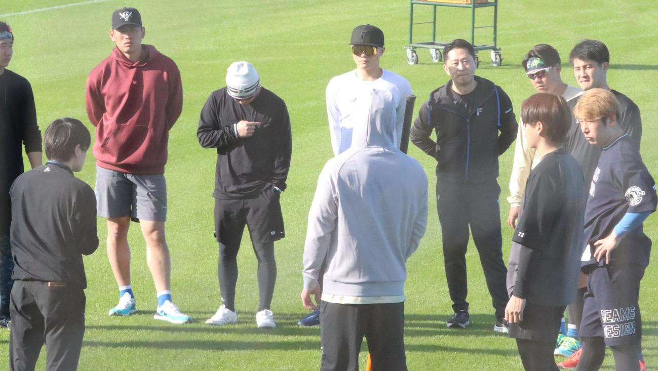 自主トレ開始前にスタッフの説明を聞く日本ハム菊地（右奥）（撮影・永野高輔）