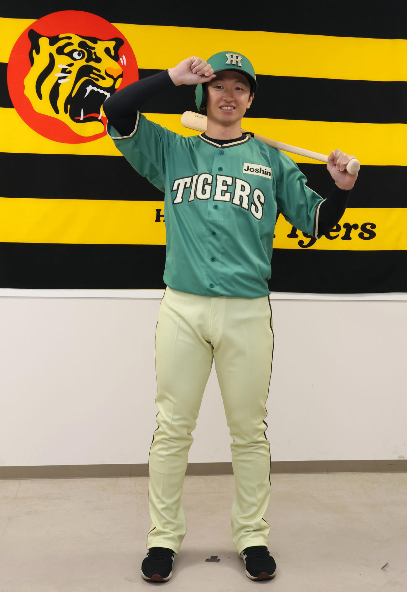 阪神近本がスタジアムヒーロズデイユニホームのお披露目会見を行い、バットをかかえて写真に納まる（撮影・加藤哉）
