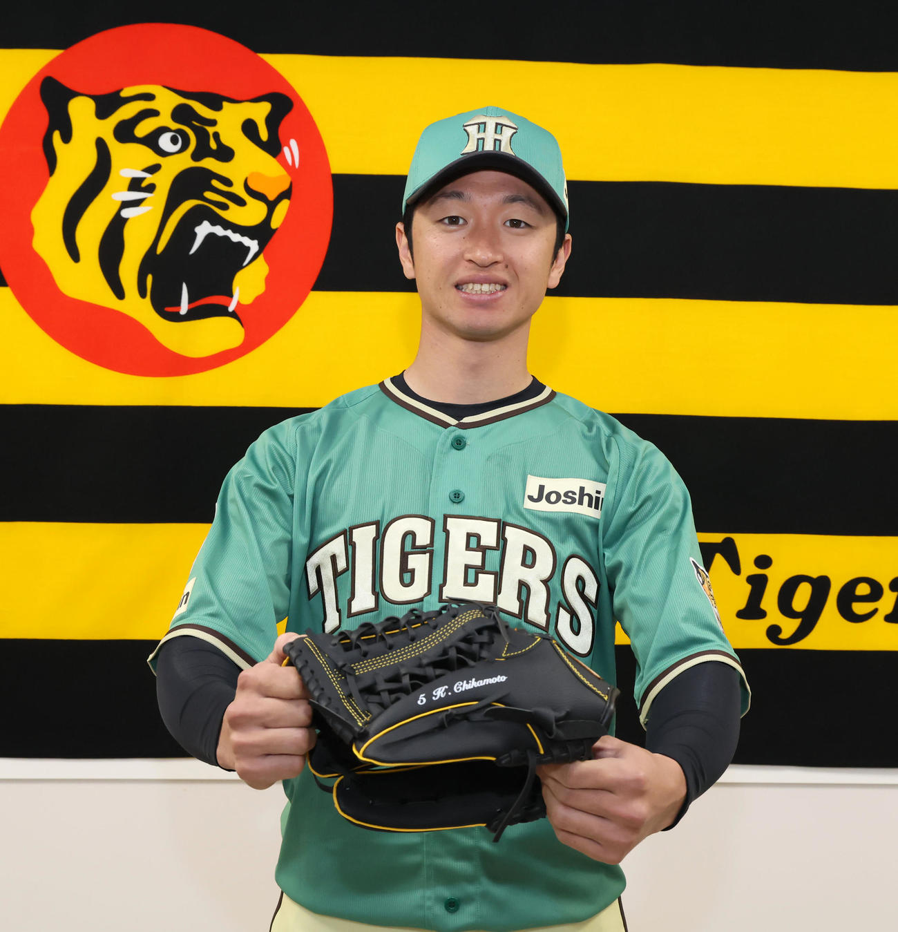 スタジアムヒーロズデーユニホームのお披露目会見を行い、自身監修のグラブを持って写真に納まる阪神近本光司（撮影・加藤哉）