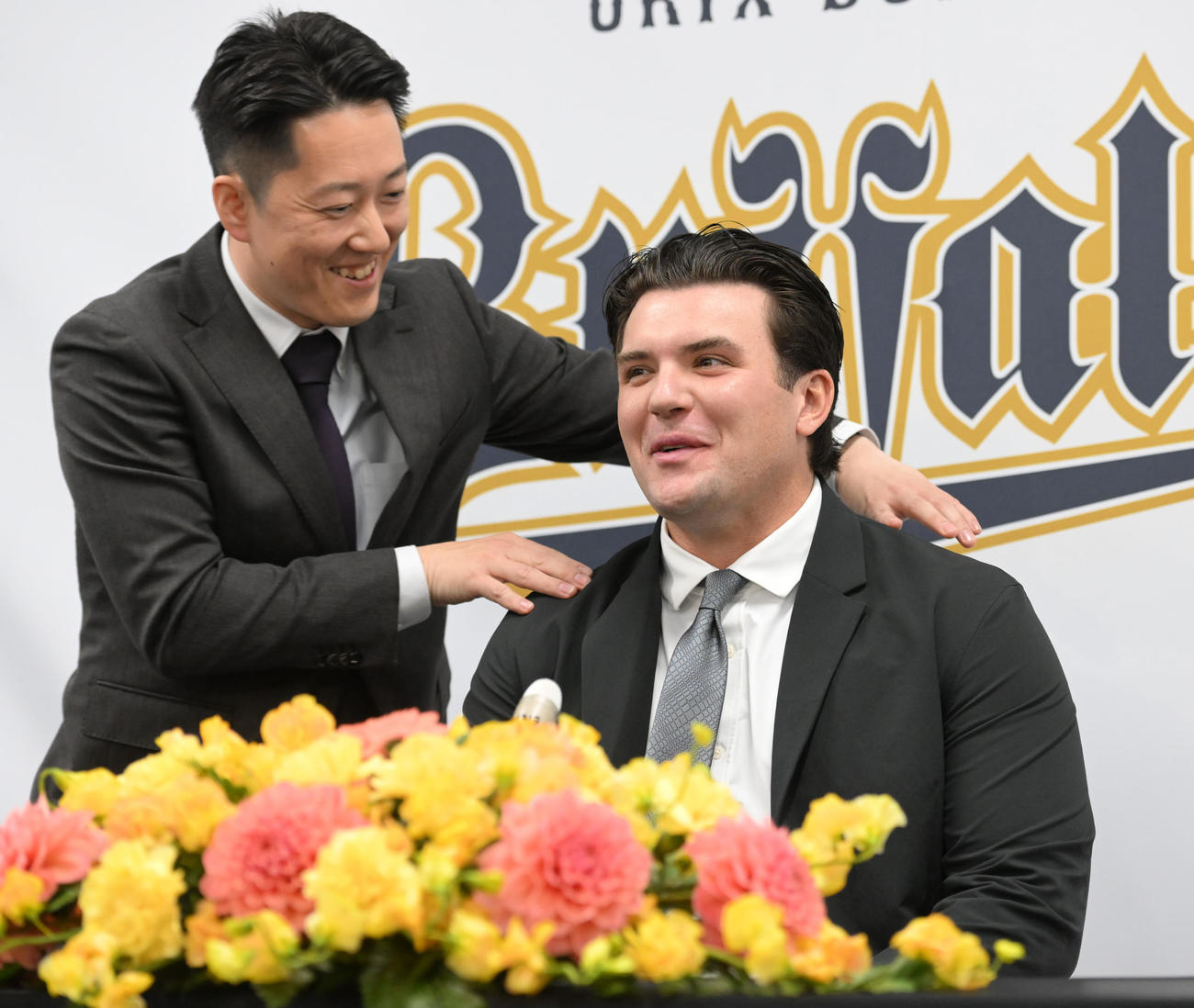 入団会見を前に沢村通訳から肩をもまれるオリックスのボブ・シーモア（撮影・和賀正仁）