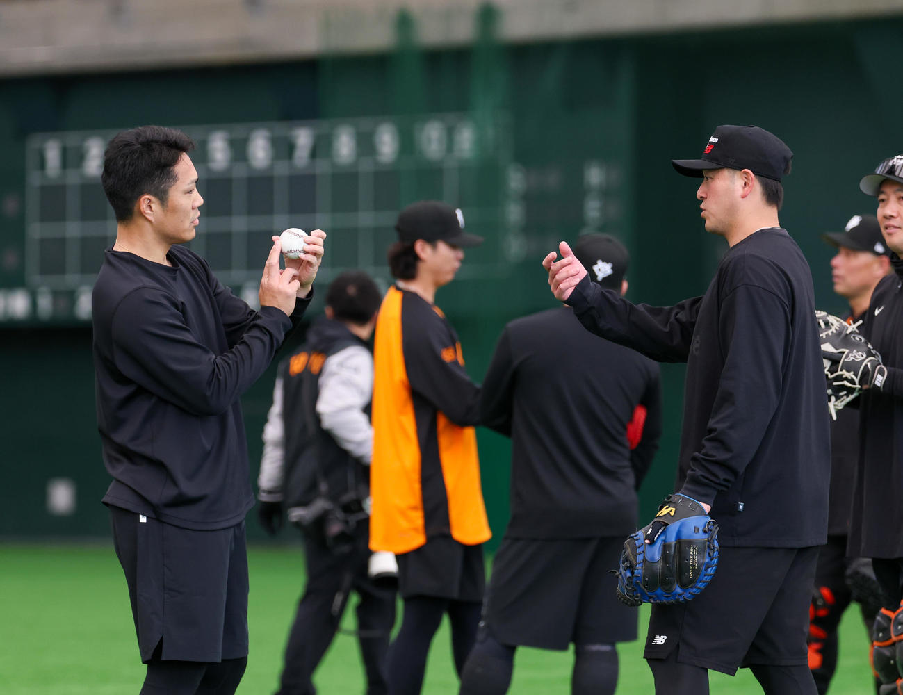 合同自主トレで投げ終え岸田（右）とボールの回転について話す巨人則本（撮影・増田悦実）