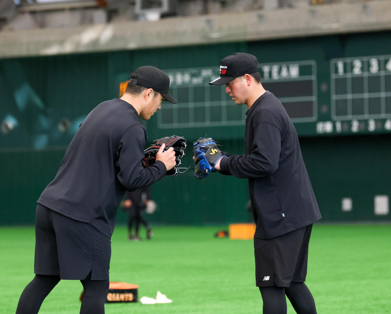 合同自主トレで投球し終え岸田（左）とタッチを交わす巨人則本（撮影・増田悦実）