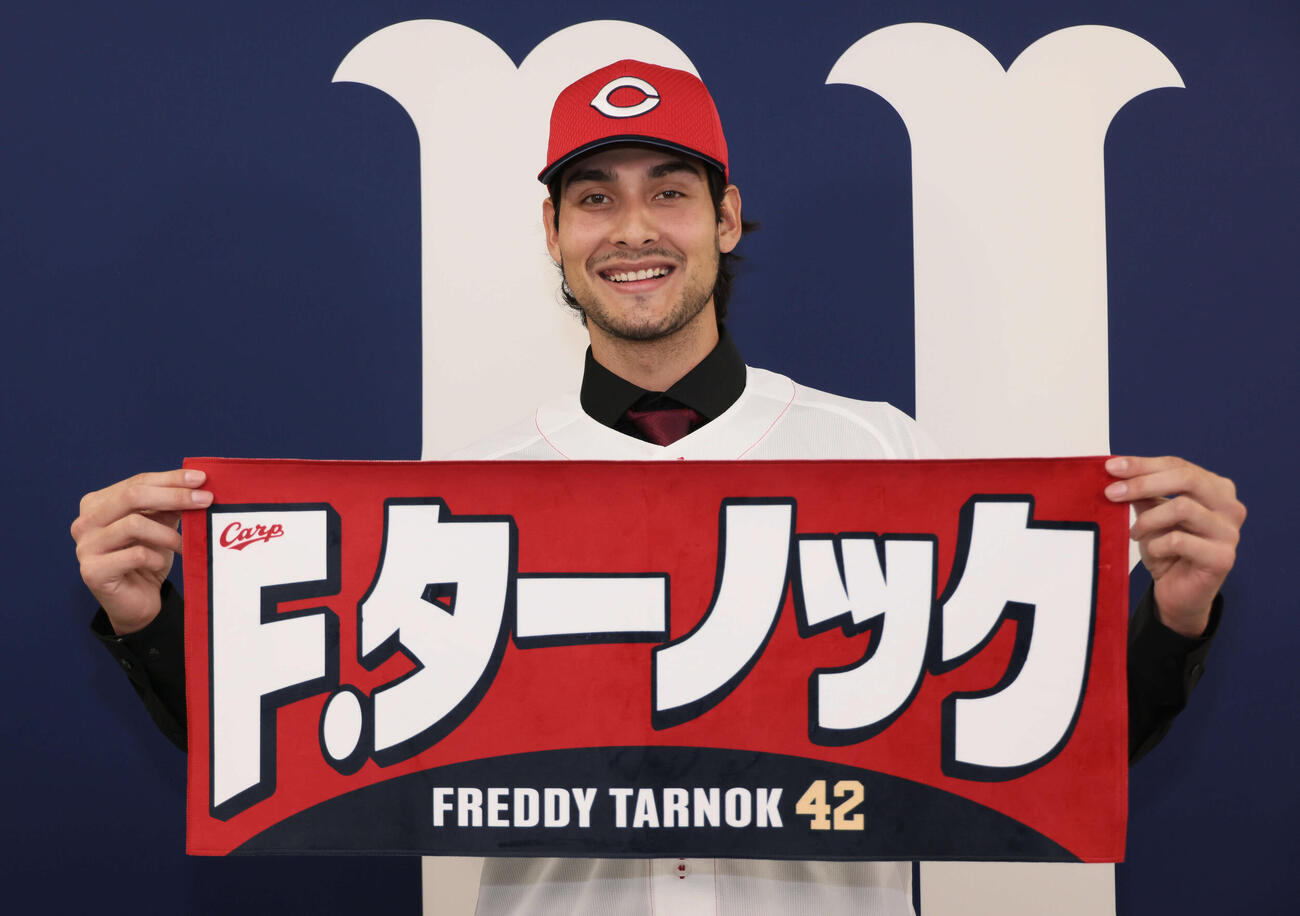 入団会見後、自身のグッズを手にする広島ターノック（撮影・加藤孝規）