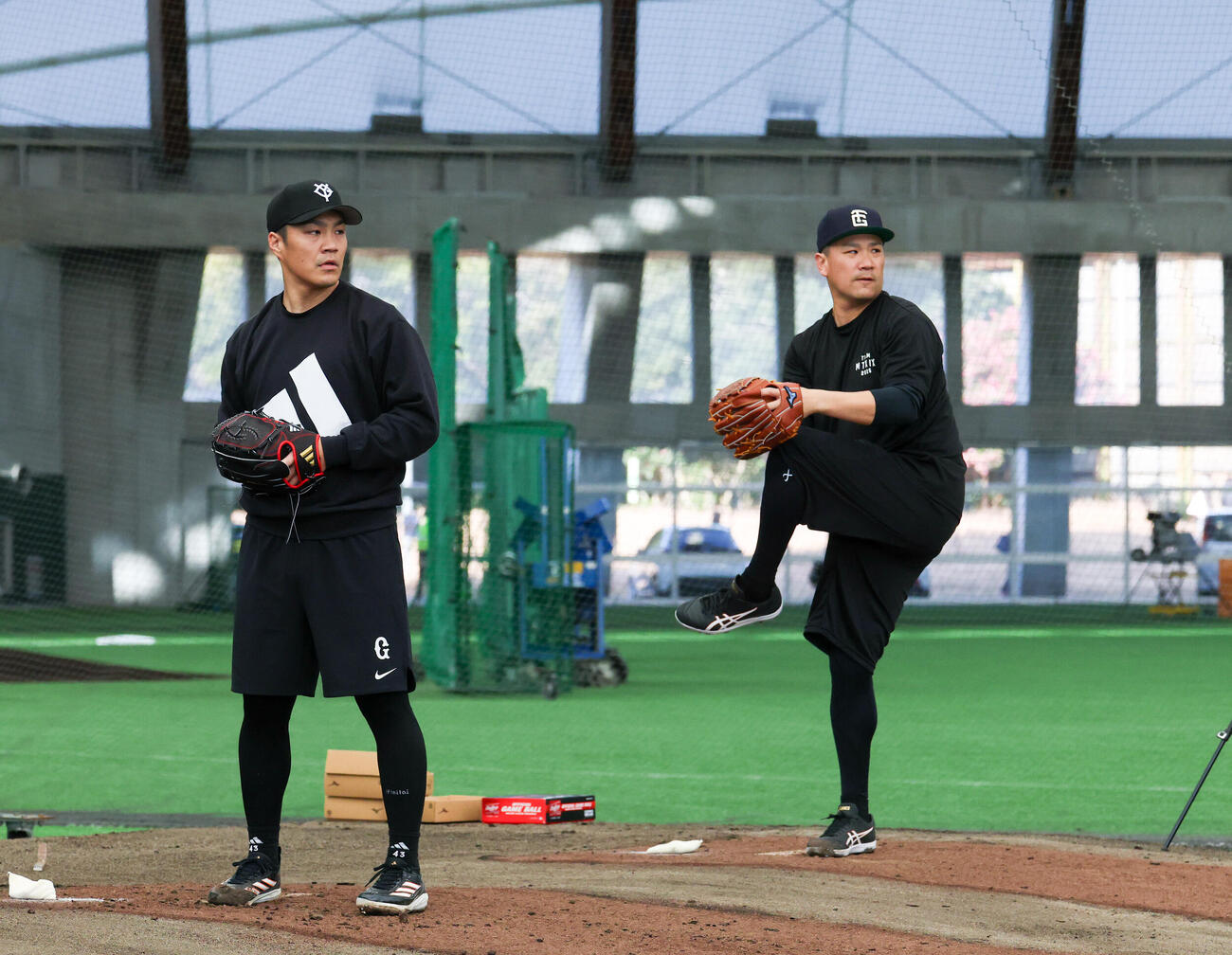 合同自主トレで並んでブルペンで投げる巨人則本（左）と田中将（撮影・増田悦実）