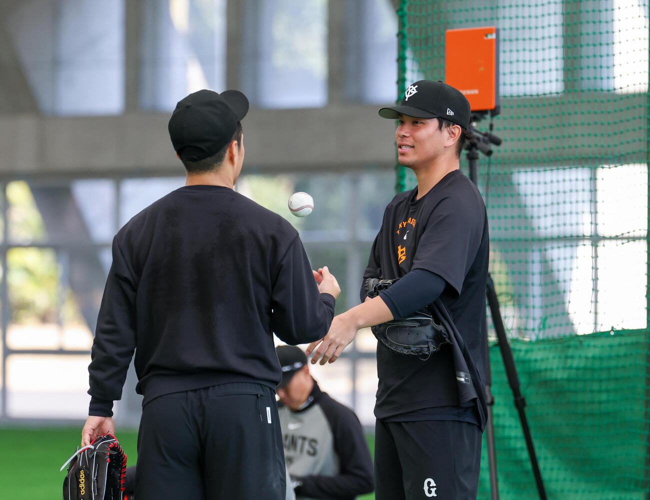 合同自主トレで投球後の則本（左）と話す巨人大城（撮影・増田悦実）