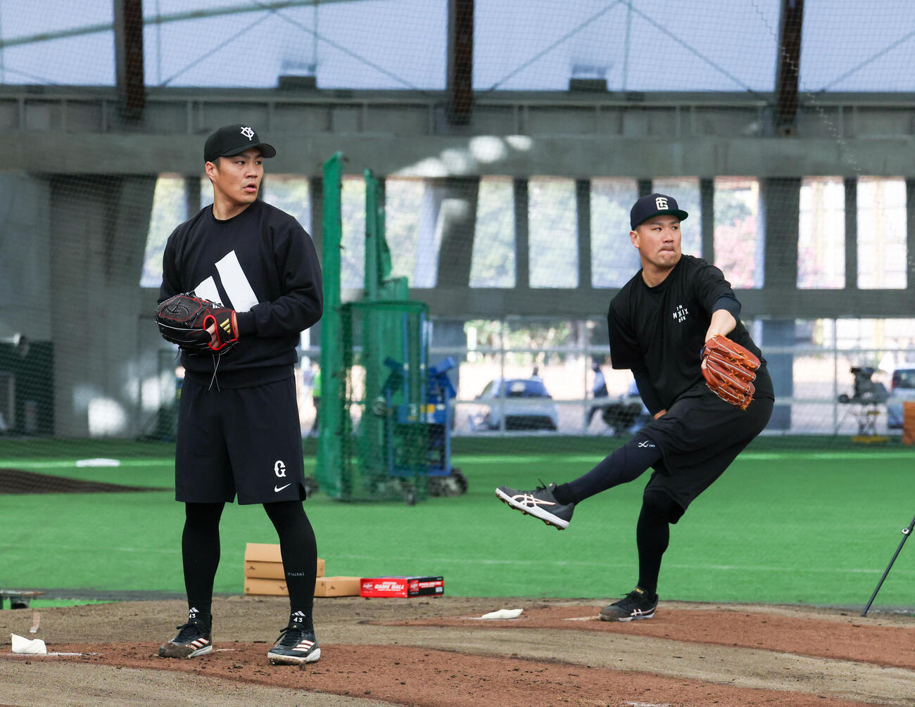 合同自主トレで並んでブルペンで投げる巨人則本（左）と田中将（撮影・増田悦実）