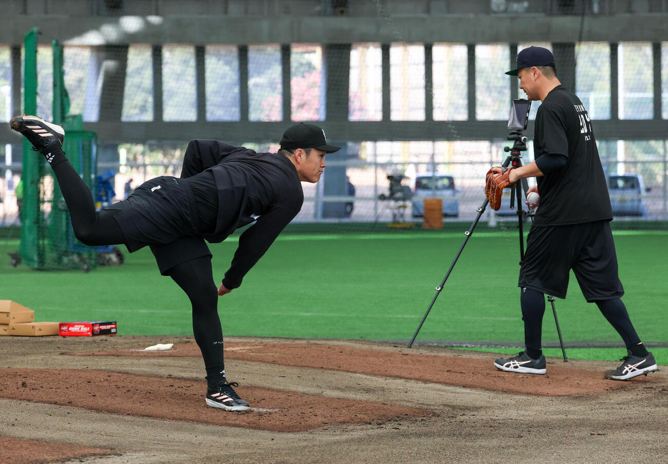 合同自主トレで並んでブルペンで投げる巨人則本（左）と田中将（撮影・増田悦実）