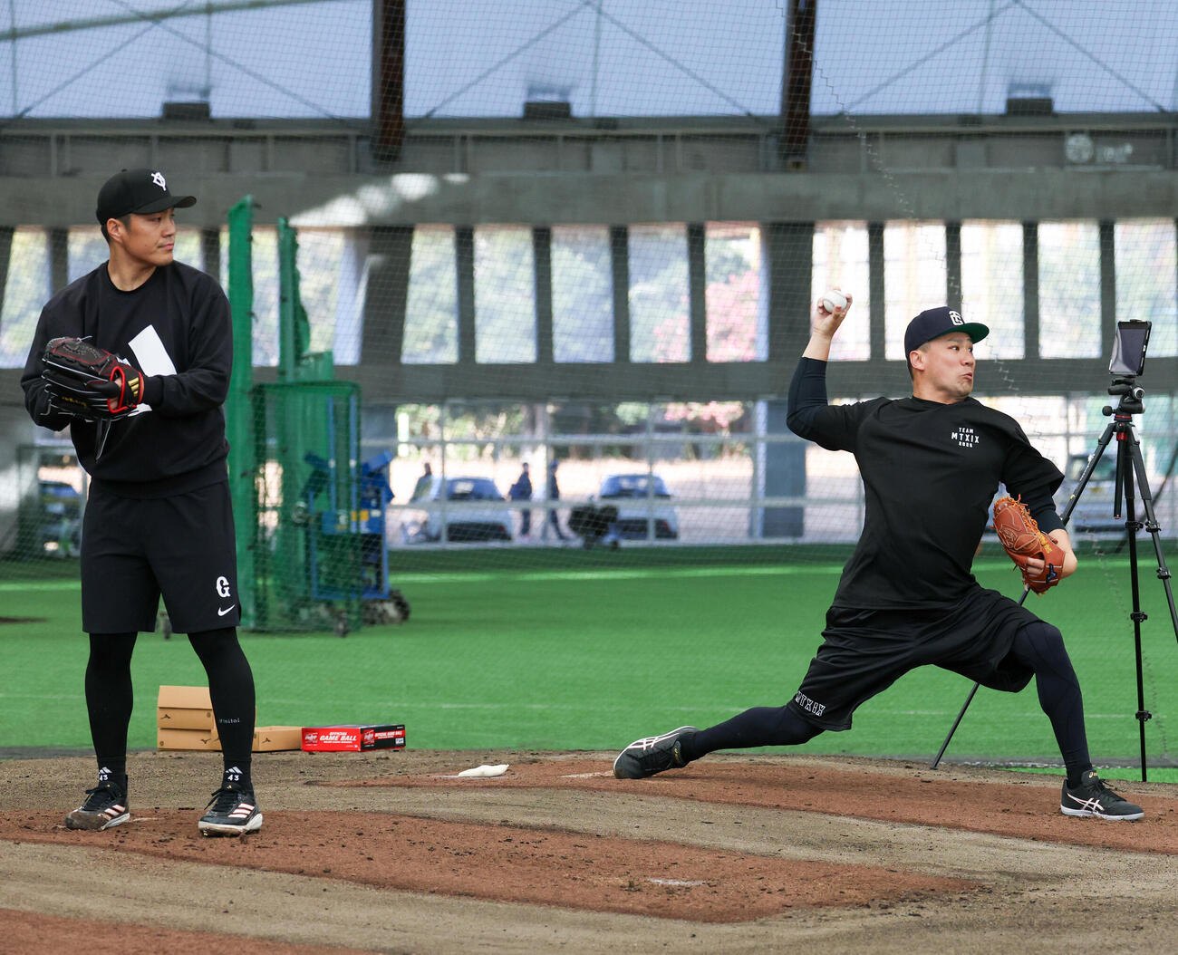 合同自主トレで並んでブルペンで投げる巨人則本（左）と田中将（撮影・増田悦実）