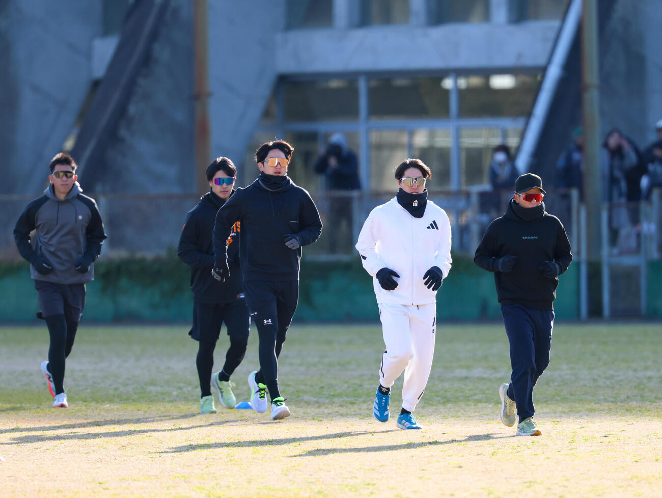 合同自主トレ開始時、風が強く防寒しアップをする大勢（右から2人目）ら巨人ナイン（撮影・増田悦実）