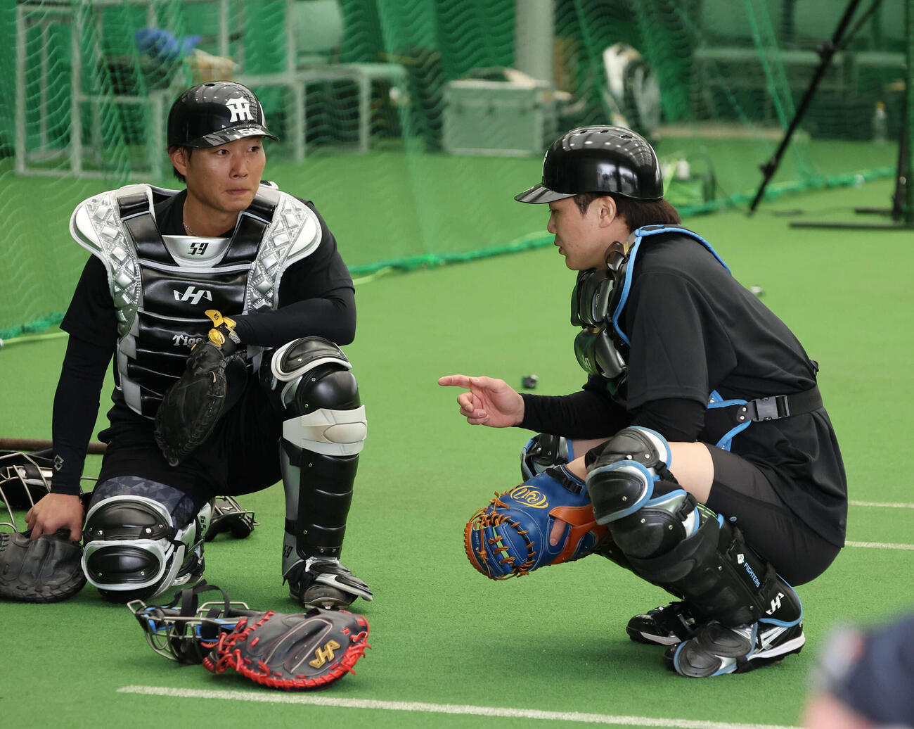 ブルペンで藤田（左）と話す伏見（撮影・西尾就之）
