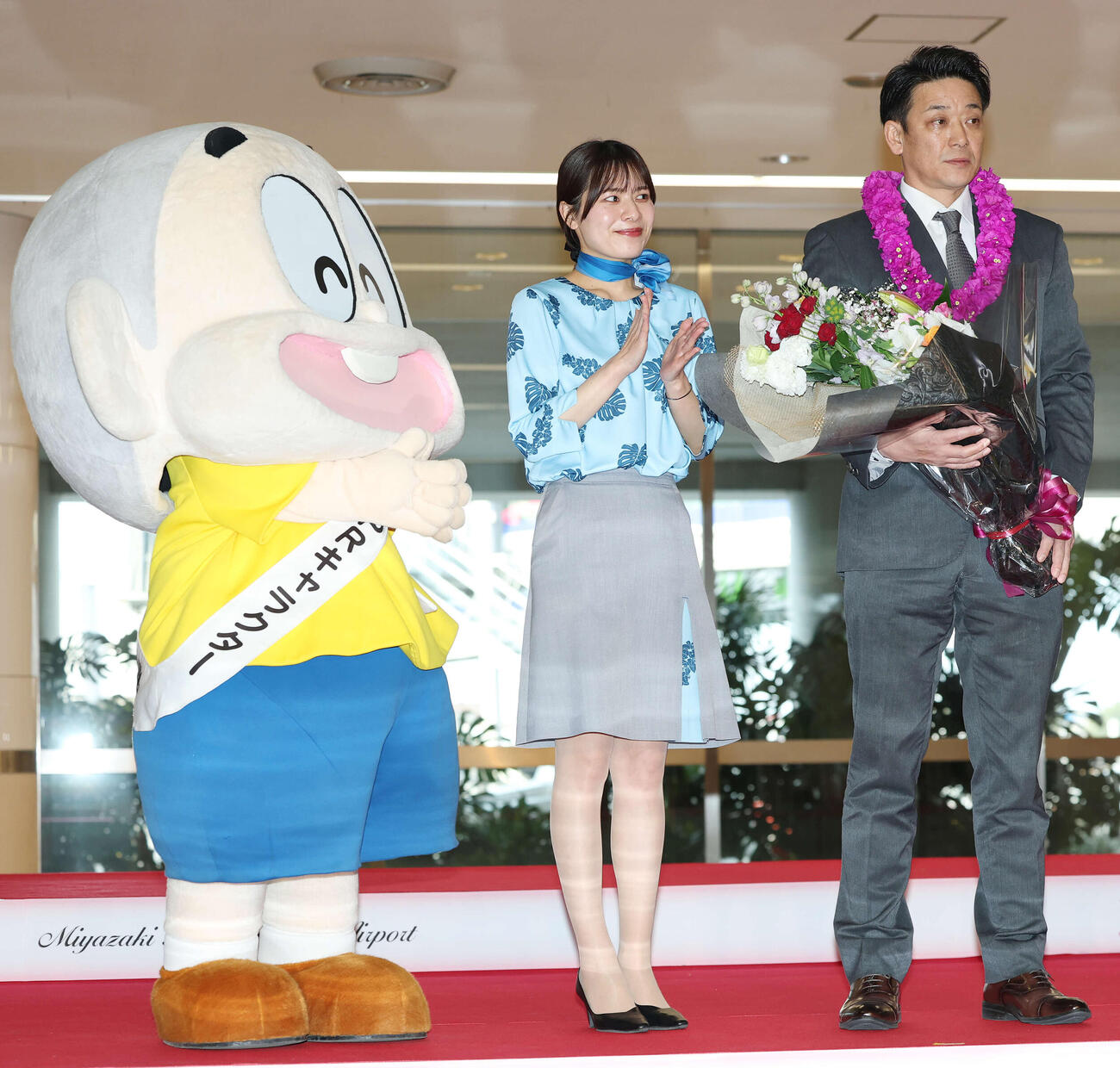 宮崎空港に到着し歓迎セレモニーを受けたロッテのサブロー監督。左は都城市PRキャラクター兼PR本部長のぼんちくん（撮影・宮地輝）