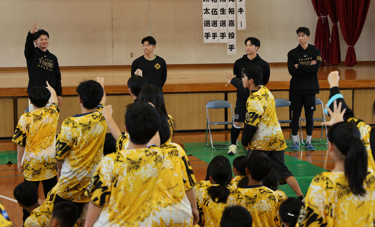 沖縄・うるま市の田場小学校を訪問し、生徒とじゃんけんゲームをする（左から）阪神森下、谷端、井坪、今朝丸（撮影・西尾就之）