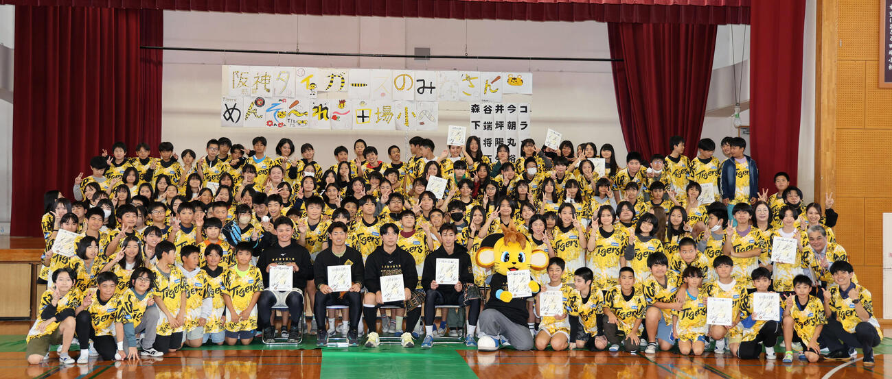 沖縄・うるま市の田場小学校を訪問した（中央左から）阪神森下、谷端、井坪、今朝丸は参加した生徒たちと記念写真に納まる（撮影・西尾就之）
