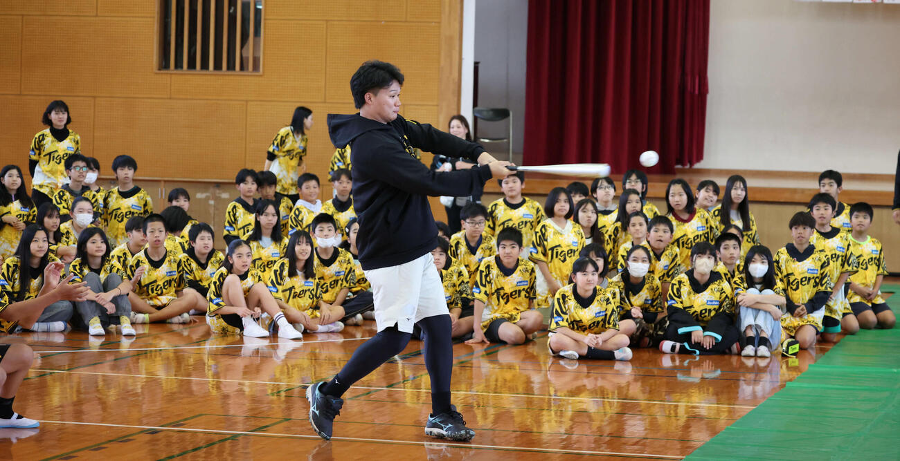 沖縄・うるま市の田場小学校を訪問し、生徒の前で打撃を披露する阪神森下（撮影・西尾就之）
