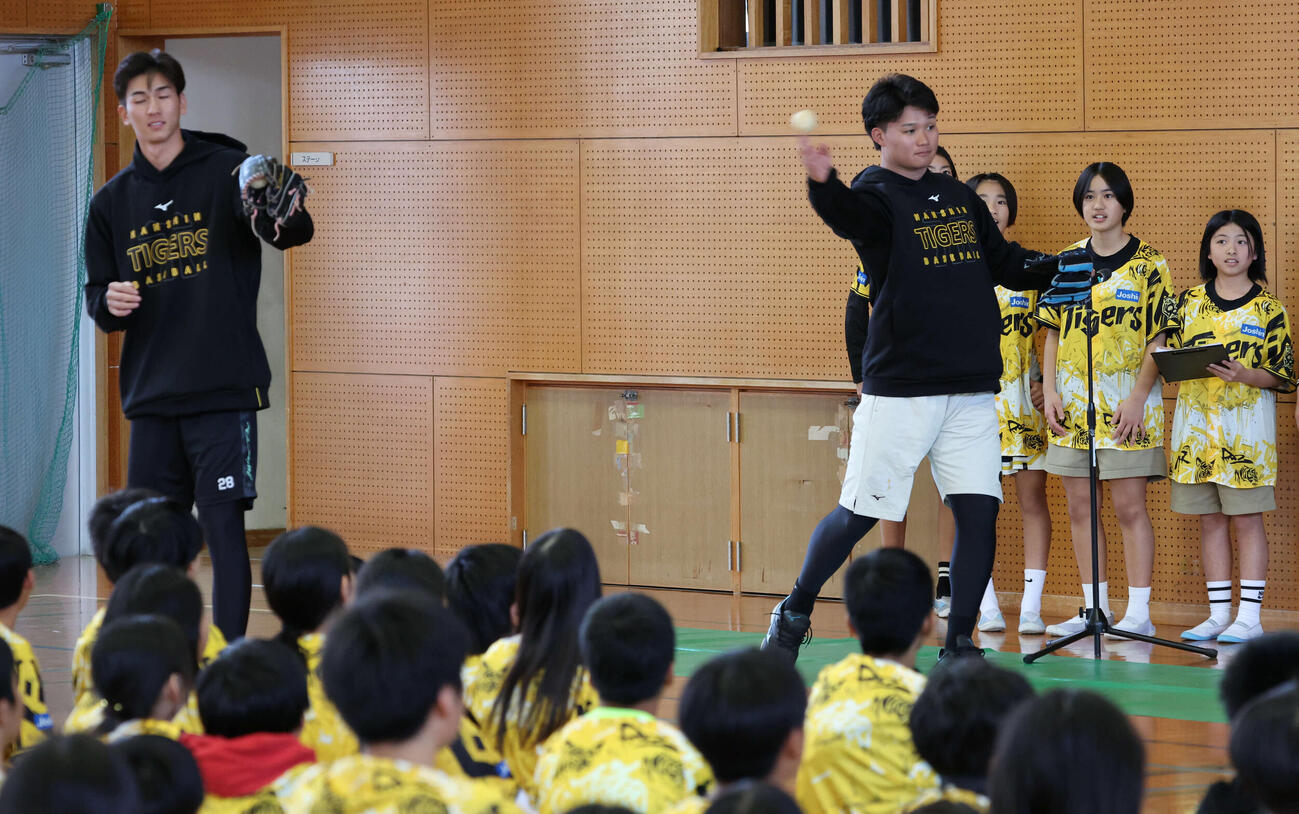 沖縄・うるま市の田場小学校を訪問し、生徒の前でキャッチボールを披露する阪神森下（右）と今朝丸（撮影・西尾就之）
