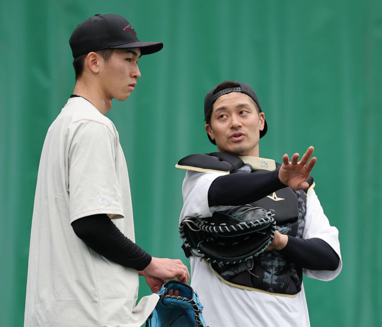 ブルペン投球を終えた今朝丸（左）と話す阪神坂本（撮影・西尾就之）