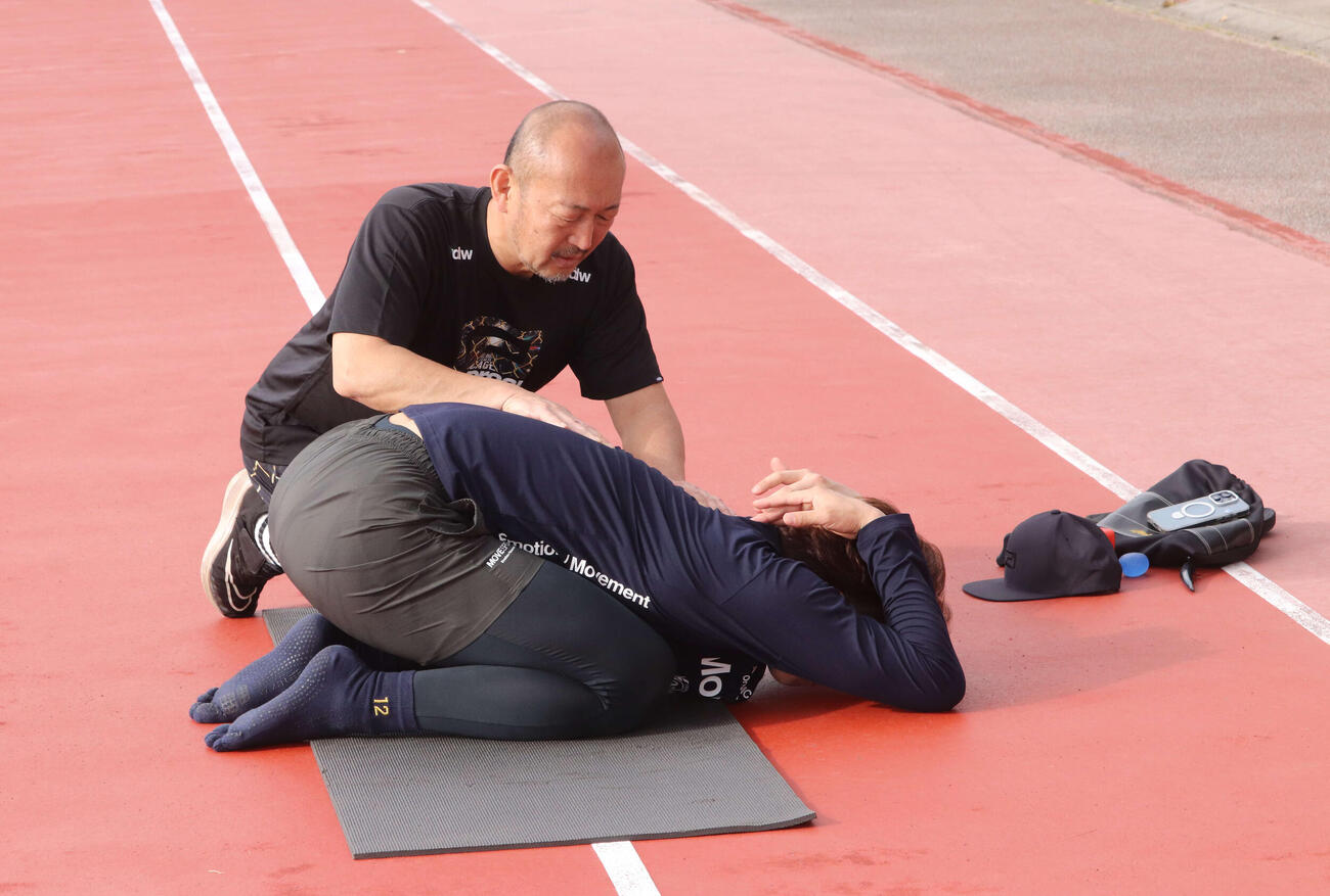 ストレッチするDeNA入江（手前）と宮崎トレーナー（撮影・小早川宗一郎）