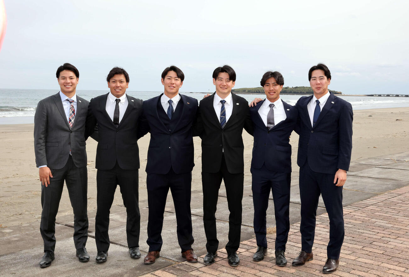キャンプ入りを前に、青島を背に記念撮影する、左から巨人田和、知念、皆川、竹丸、山城、小浜（撮影・浅見桂子）