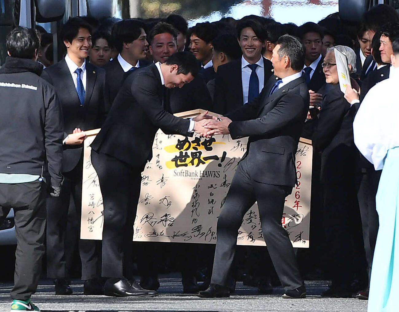 丸刈りとなった栗原（左）の姿を見て驚きながら握手を交わすソフトバンク小久保監督（撮影・岩下翔太）