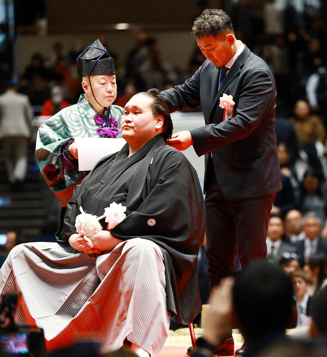 元横綱照ノ富士の伊勢ケ浜親方（左）の断髪式ではさみを入れる中田翔氏（撮影・野上伸悟）