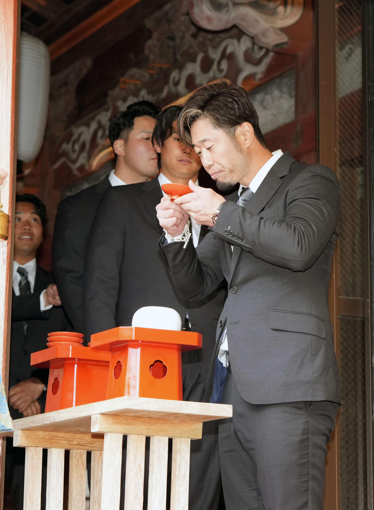 榎原神社で無事息災祈願を終えお神酒を飲む西武外崎（撮影・小島史椰）