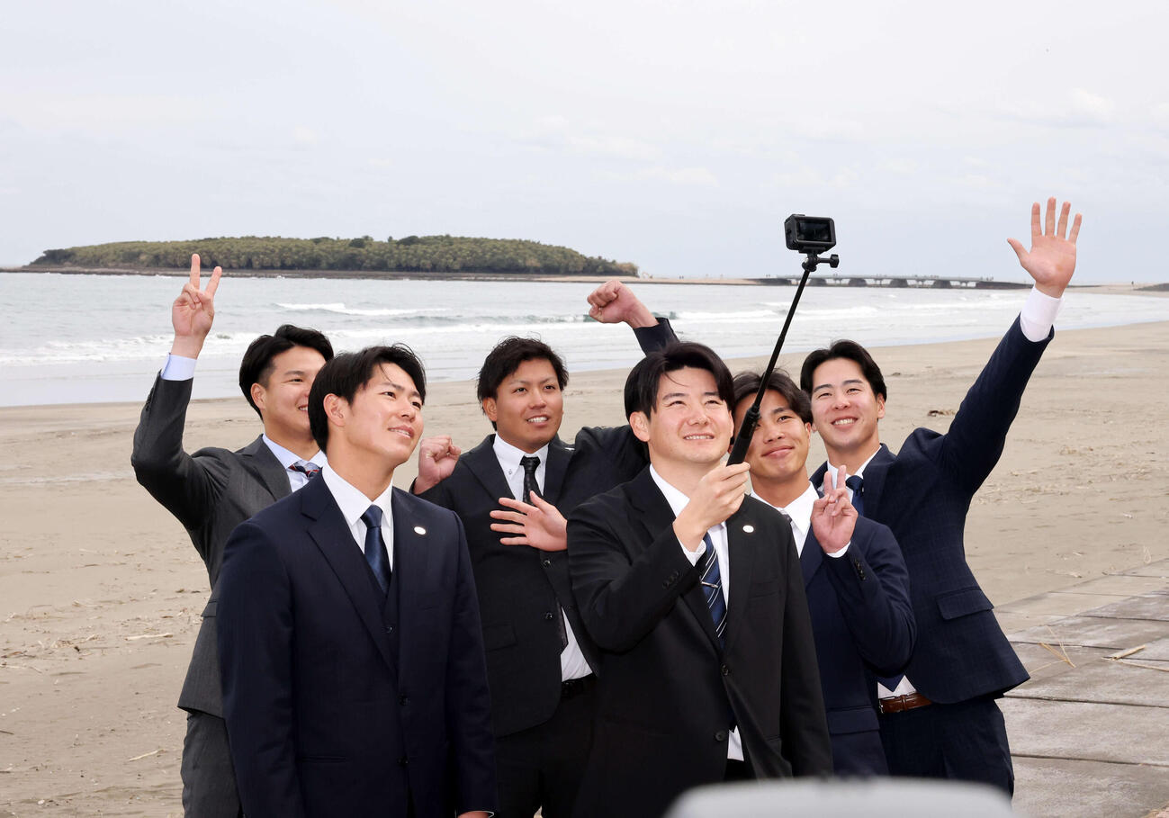キャンプ入りを前に、青島を背に記念撮影する、左から巨人田和、皆川、知念、竹丸、山城、小浜（撮影・浅見桂子）