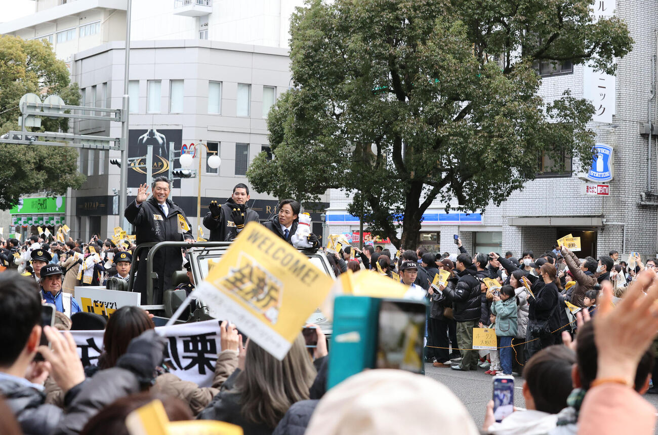 キャンプ前日のパレードで大勢のファンに向かって笑顔で手を振るソフトバンク小久保監督、中央は栗原、右は野村（撮影・梅根麻紀）