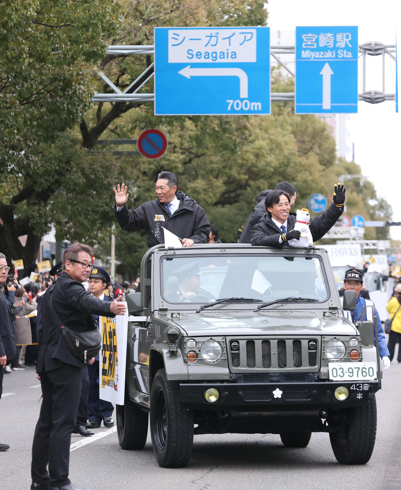 キャンプ前日のパレードで大勢のファンに向かって笑顔で手を振るソフトバンク小久保監督、中央は栗原、右は野村（撮影・梅根麻紀）