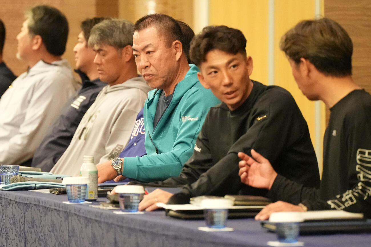 全体ミーティング会場の席に着く右から山井投手コーチ、嶋ヘッドコーチ、井上監督（撮影・森本幸一）