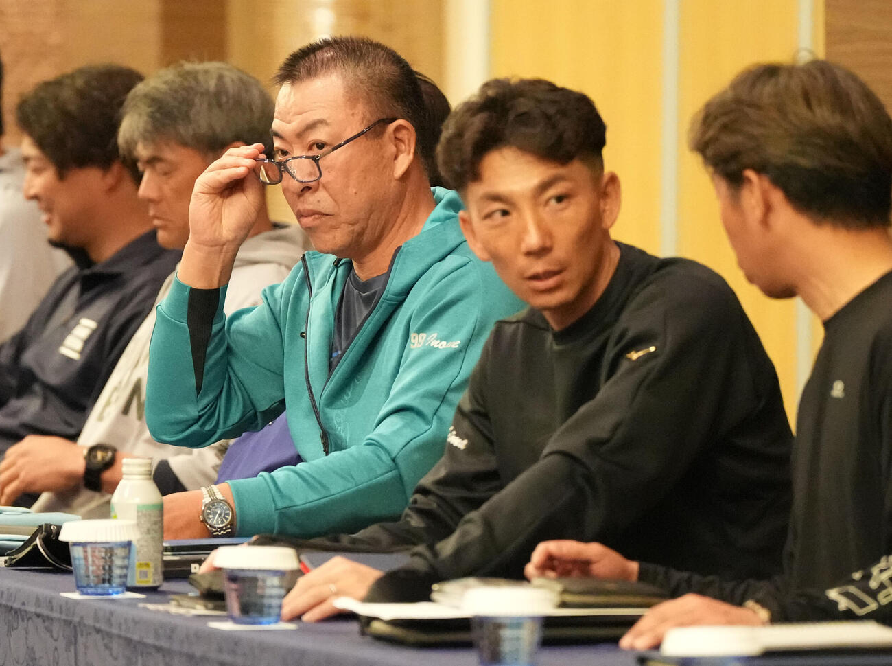 全体ミーティング会場の席に着く右から山井投手コーチ、嶋ヘッドコーチ、井上監督（撮影・森本幸一）