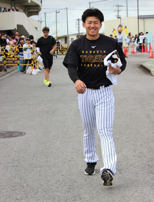 白い歯を見せながら歩く阪神立石（撮影・柏原誠）＝2026年2月1日
