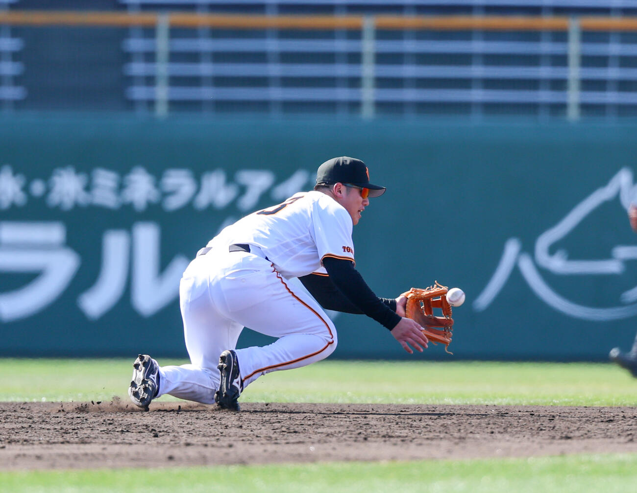春季キャンプでノックの球をつまずきながら捕球する巨人石塚（撮影・増田悦実）