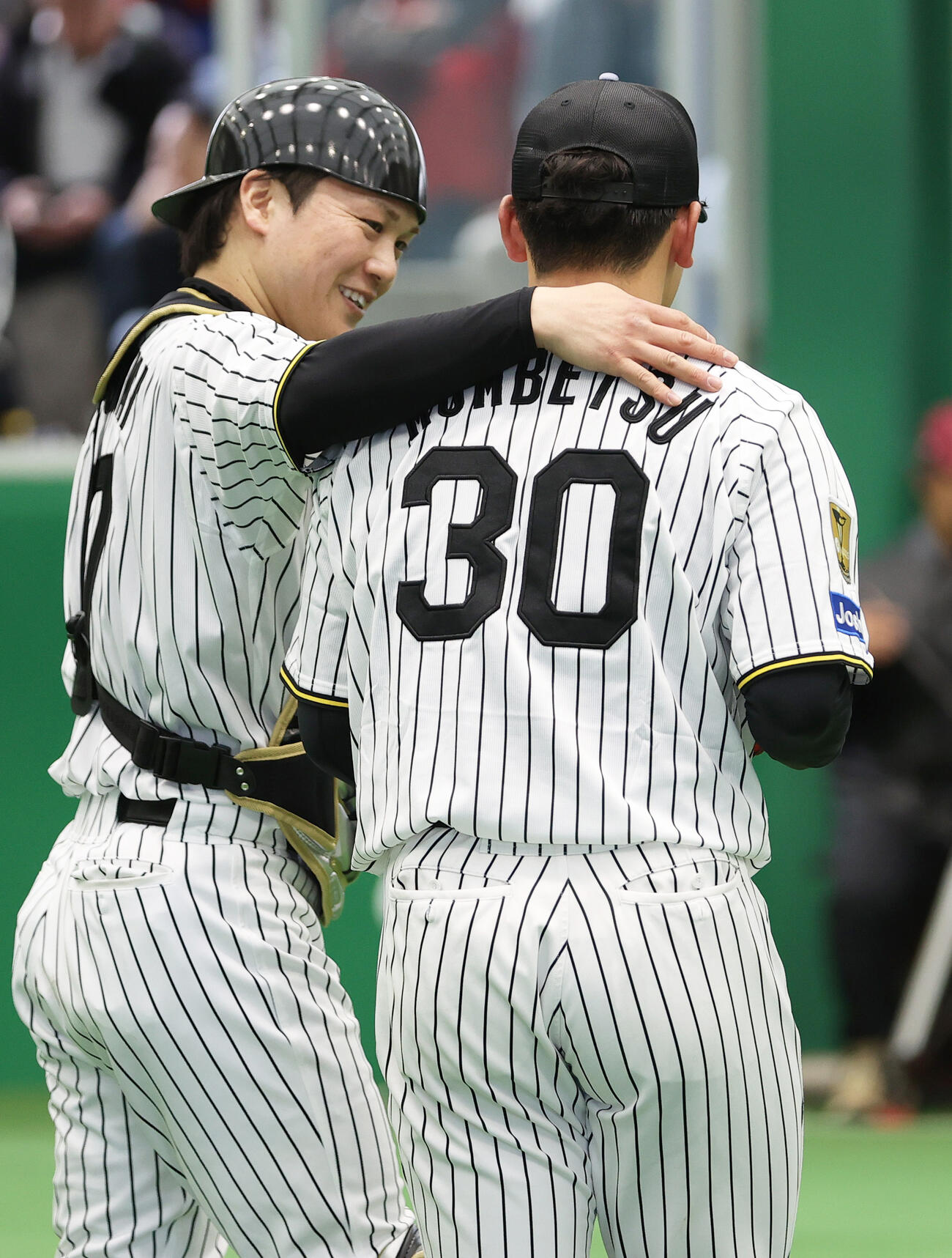 阪神伏見（左）はブルペンで投球を終えた門別の肩を寄せる（撮影・上山淳一）