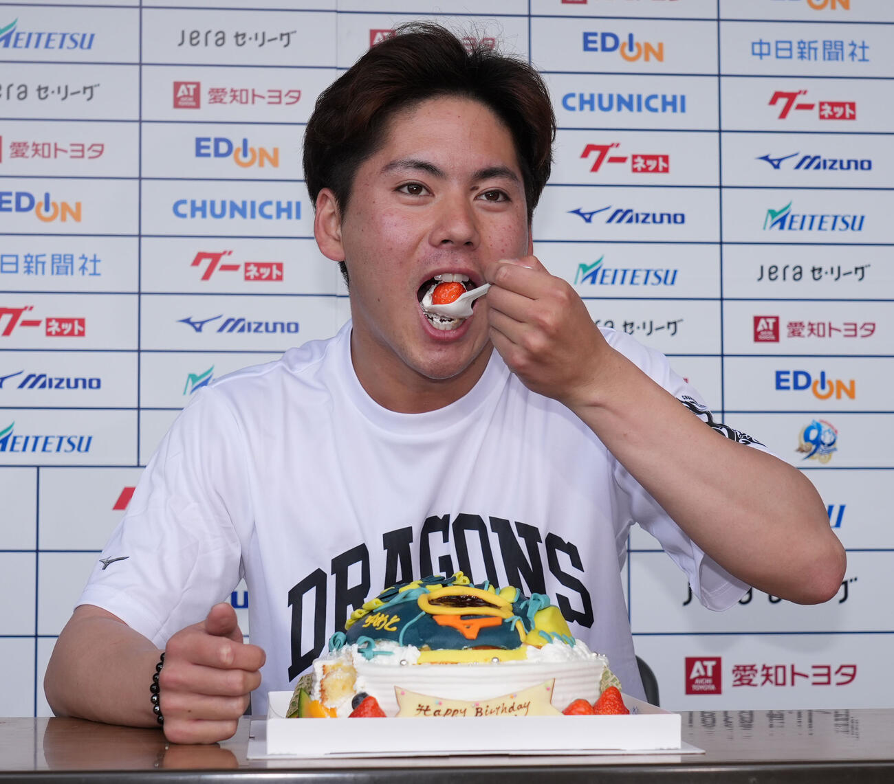 トレーニング終了後に今日、誕生日を迎えた金丸は報道陣から贈られたバースデーケーキをほおばる（撮影・森本幸一）