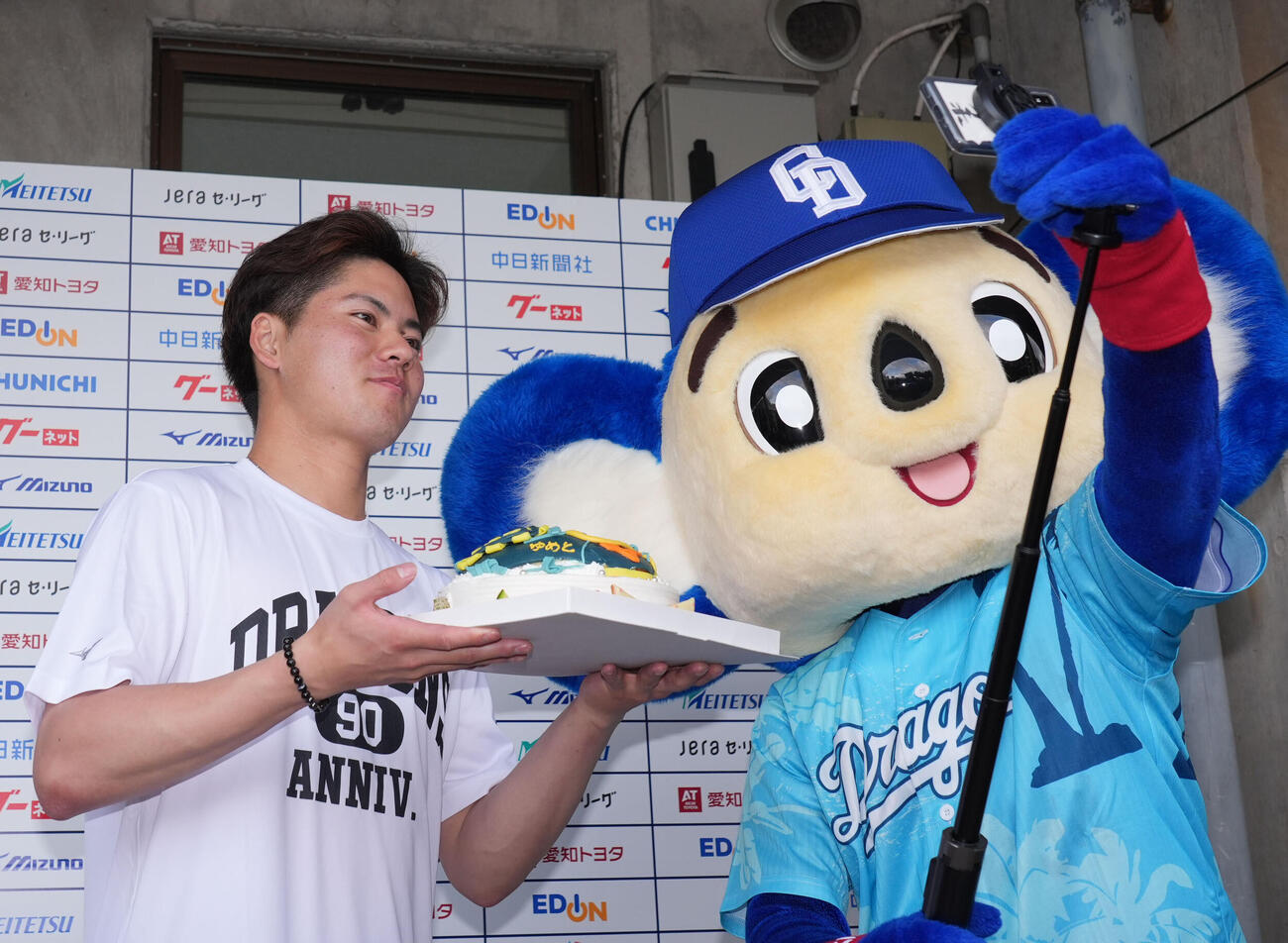 トレーニング終了後に今日、誕生日を迎えた金丸（左）は報道陣から贈られたバースデーケーキを手にドアラと記念撮影をする（撮影・森本幸一）