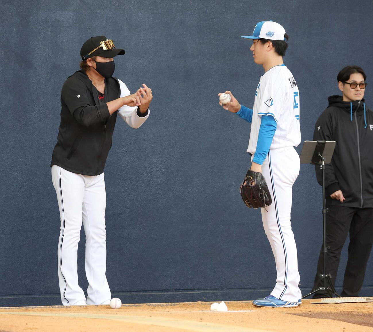 新庄監督（左）から指導を受ける日本ハム北山（撮影・黒川智章）