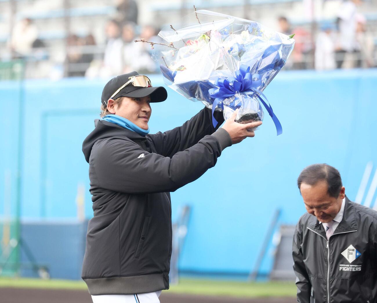 セレモニーで名護市長から花束を受け取る新庄監督（撮影・黒川智章）