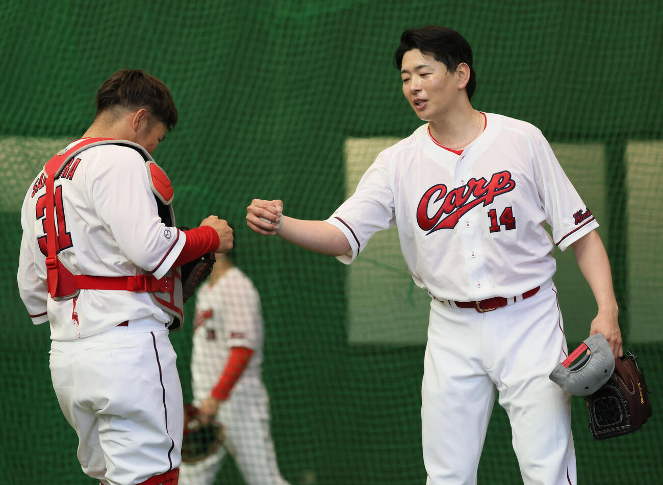 ブルペンで投げた広島大瀬良（右）は坂倉とグータッチ（撮影・加藤孝規）